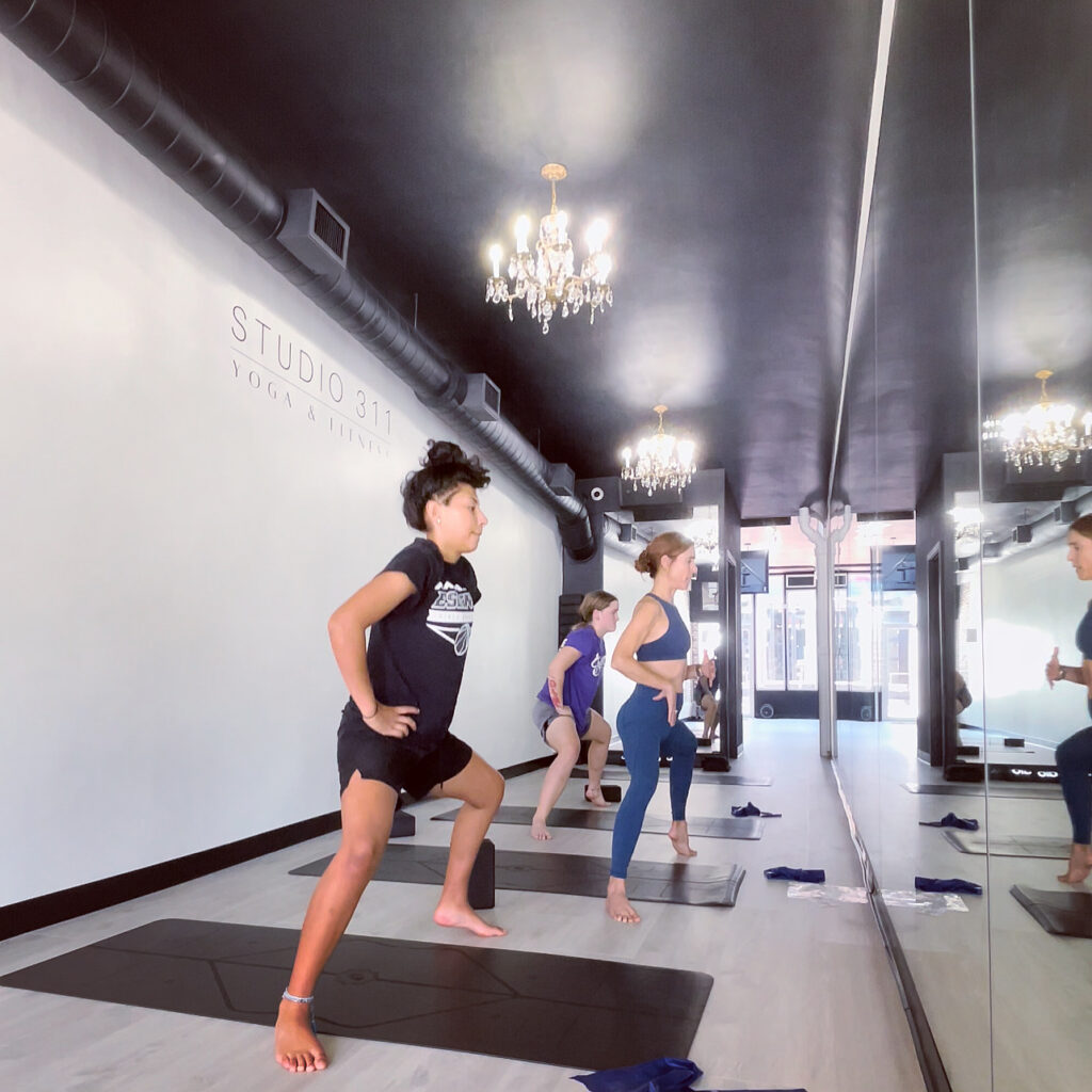 Sherri is in the studio at Studio 311 Yoga & Fitness. She is training with two young athletes for better flexibility and balance.