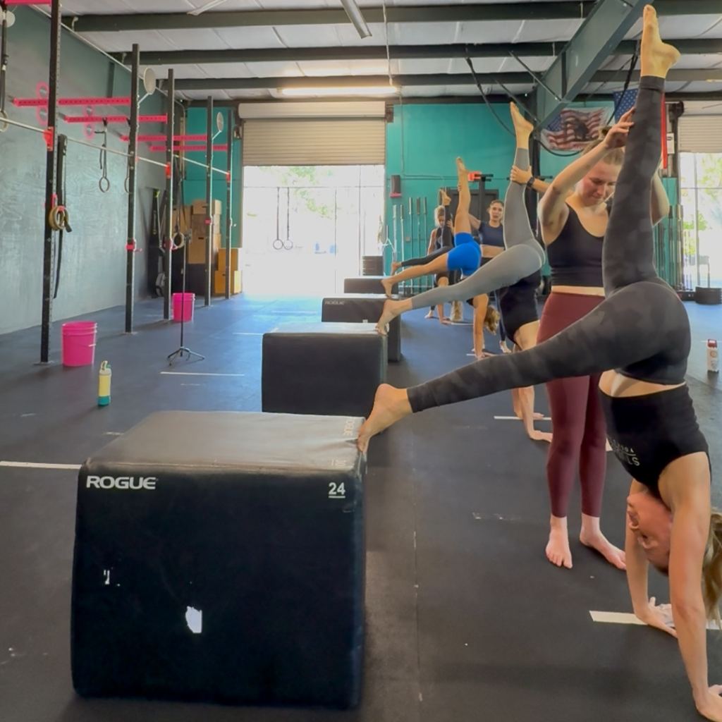 Yogis practicing balancing with blocks as support in Handstand Training in Daytona Beach.